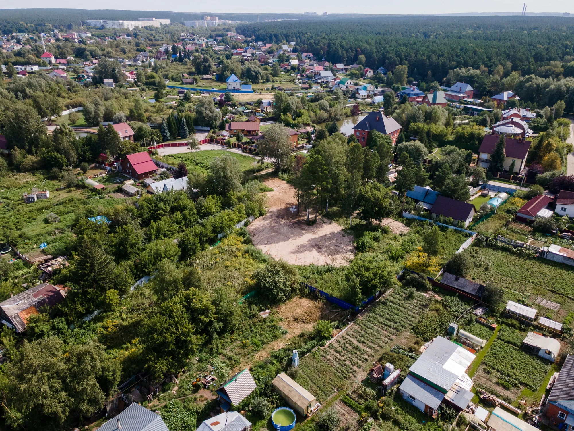 Участок с высоты: расчищенная площадка среди частного сектора